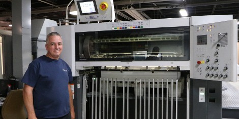 Veteran press operator John Cullen of Starnet Business Solutions pauses for a photo at the end of the company's Heidelberg Speedmaster press, which was retrofitted with an LED UV curing system from Air Motion Systems.